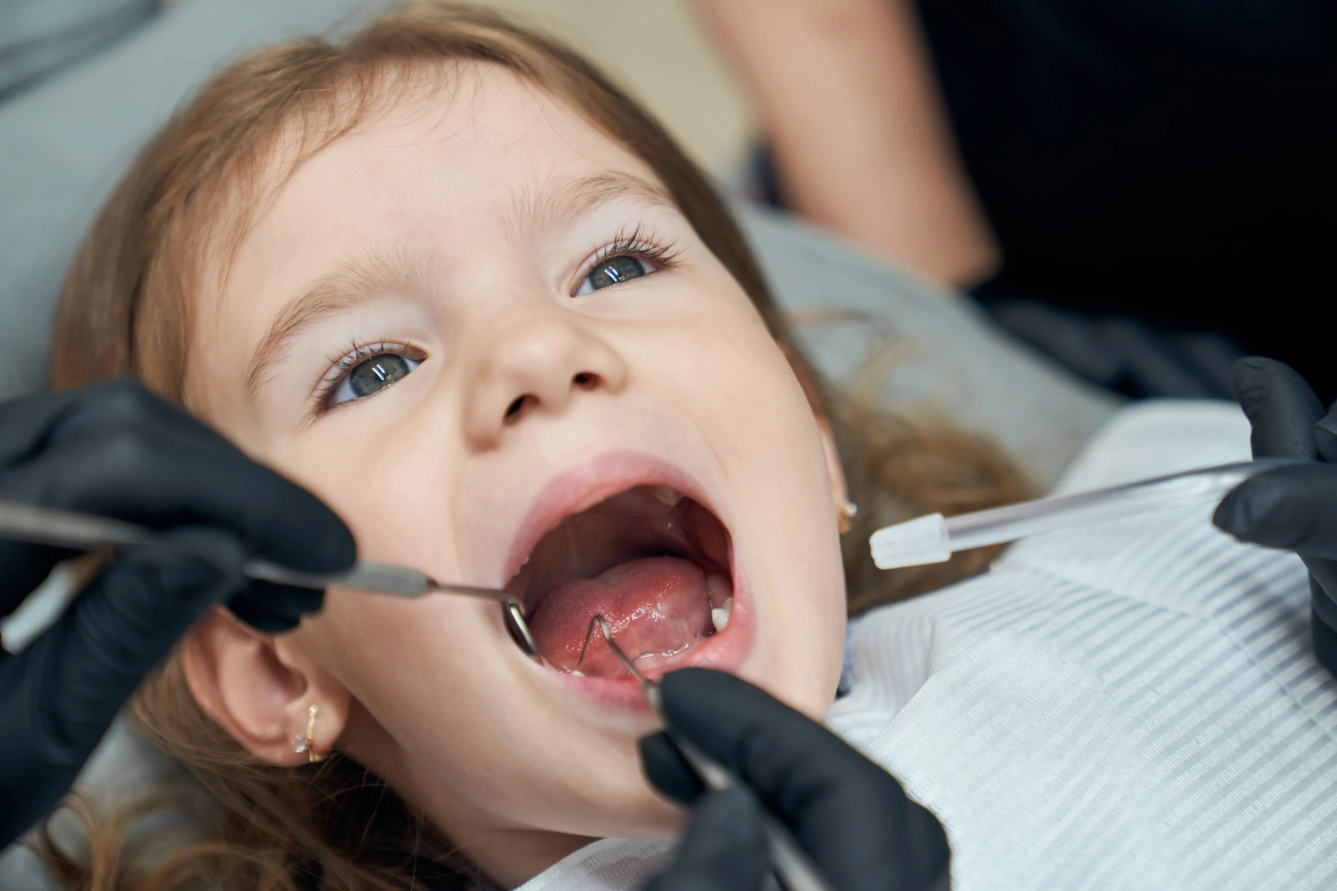 Young child receiving preventive fluoride treatment at the dentist